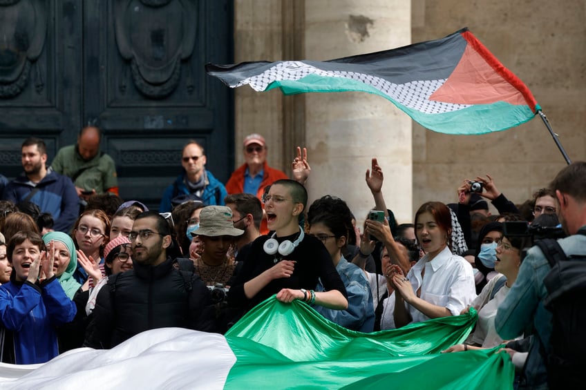 Students shout slogans and display a giant Palestinian flag as they take part in a rally in support of Palestinians at the Sorbonne University in Paris on April 29, 2024. Students gathered at midday on April 29, 2024 at the Sorbonne to express their support for the Palestinians in front of the building and inside the university, where they set up tents, following the similar action at Sciences Po of April 26, 2024, a day of blockades and mobilisation, marked by tensions. (Photo by Geoffroy VAN DER HASSELT / AFP) (Photo by GEOFFROY VAN DER HASSELT/AFP via Getty Images)