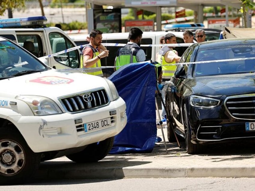 Police officers work near the body (behind blue curtain) of late ex-Ukraine MP Andrey (And