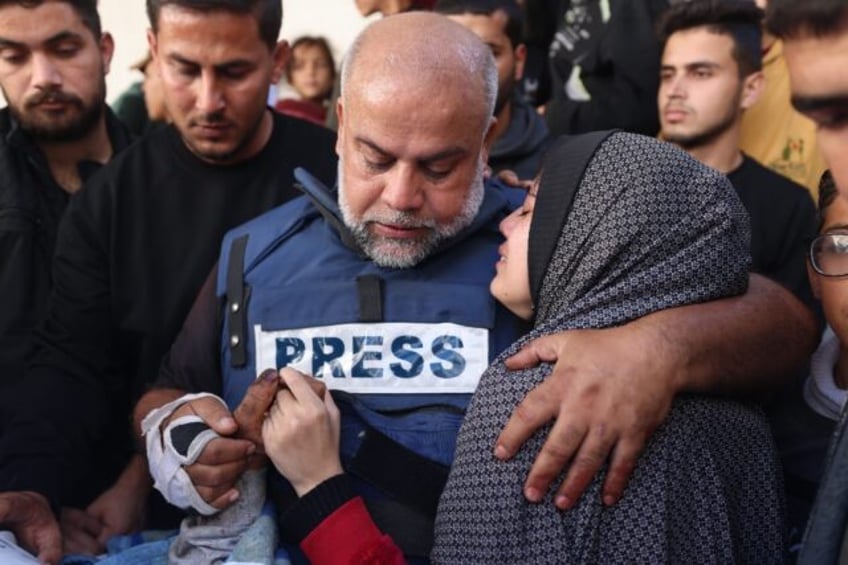 Al Jazeera's bureau chief in Gaza, Wael Al-Dahdouh (C), during the funeral of his son Hamz