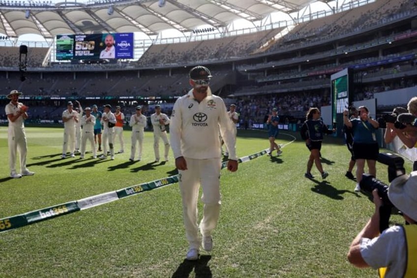 Australia's players applaud teammate Nathan Lyon (C) after he took his 500th Test wicket