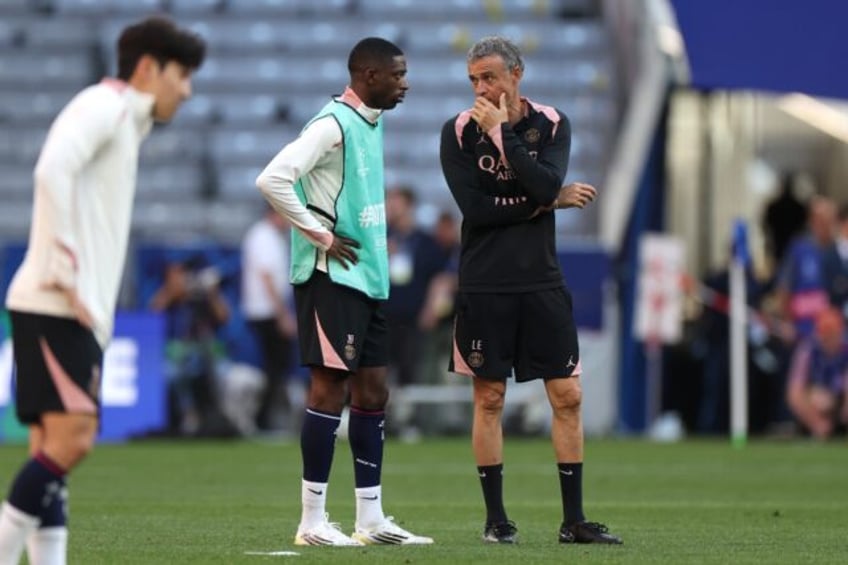 Paris Saint-Germain coach Luis Enrique (R) speaks to Ousmane Dembele on the pitch at Munic