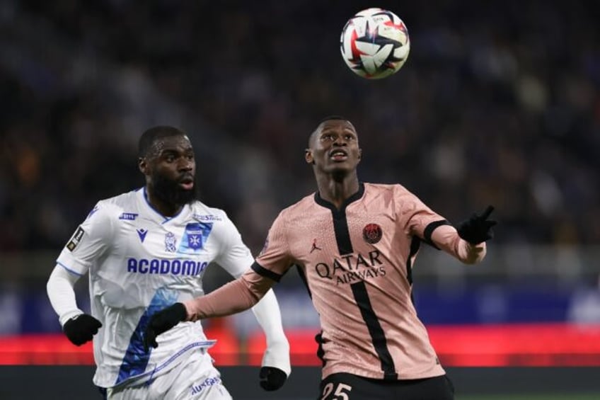 Paris Saint-Germain's Nuno Mendes (R) holds off Lassine Sinayoko of Auxerre during Friday'