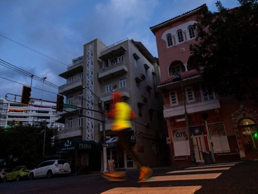 A man jogs on a dark street in San Juan, Puerto Rico after a major power outage hit the is