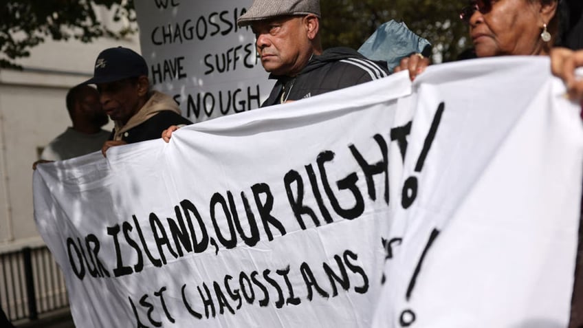 Members of the Chagossian community gather with banners and placards outside parliament to protest against the government's decision to hand the Chagos Islands over to Mauritius, on October 7, 2024. (Photo by Adrian DENNIS / AFP) (Photo by ADRIAN DENNIS/AFP via Getty Images)