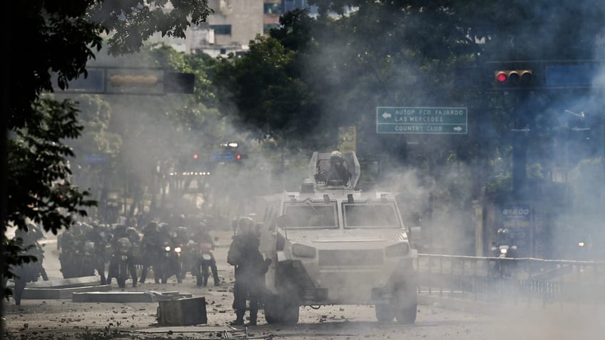 An armored police car drives through teargas during a protest against Venezuelan President Nicolás Maduro in Caracas on July 29, 2024, a day after the Venezuelan presidential election.