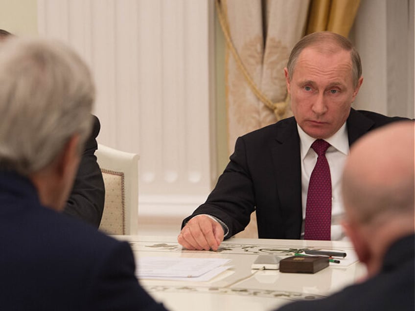 Russian President Vladimir Putin listens as U.S. Secretary of State John Kerry speaks duri