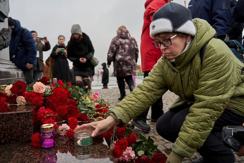A woman lays a candle to commemorate victims of Moscow terrorist attack during a memorial event in Vladivostok, Russia, March 23, 2024. Death toll has risen to 93 people in Friday's terrorist attack after gunmen stormed a concert hall in Moscow, the Investigative Committee of Russia said Saturday. (Photo by Guo Feizhou/Xinhua via Getty Images)