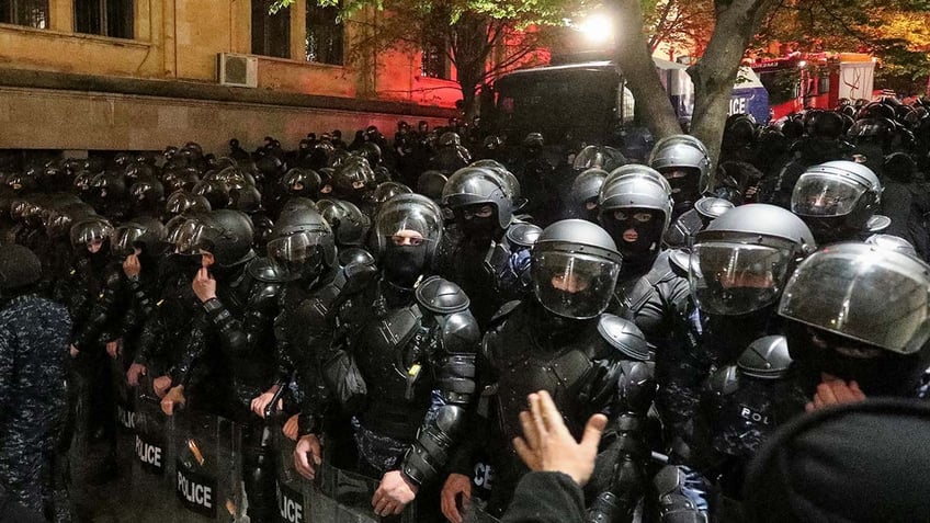 putin watches on as eastern european nation passes law favoring moscow amid violent protests