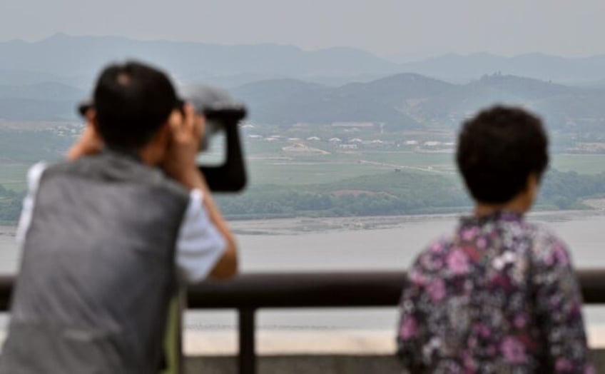 Visitors use binoculars to view the North Korean side of the Demilitarised Zone that divid