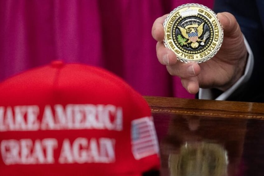 US President Donald Trump holds up a Presidential challenge coin at the White House -- but