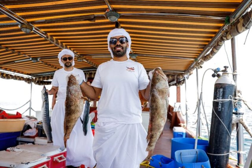 A Qatari contestant shows off his catch in a line-fishing competition that forms part of a
