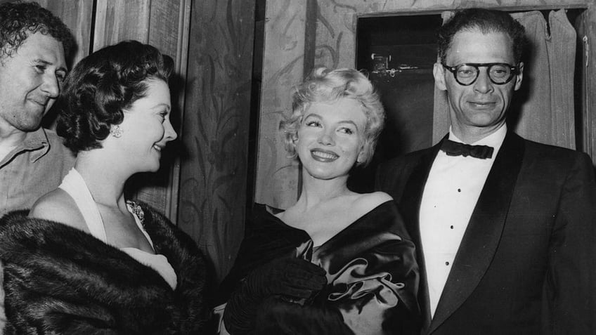 Marilyn Monroe smiling next to Arthur Miller.