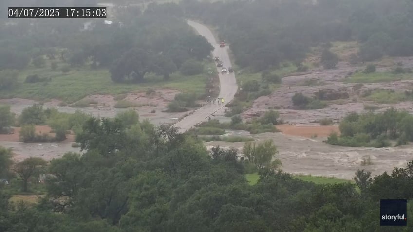 floodwaters begin overtaking small road