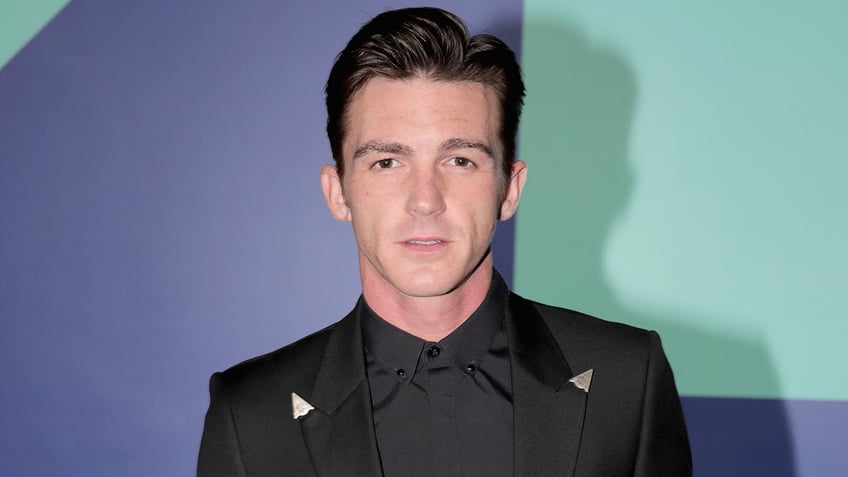 Drake Bell poses for cameras at a red carpet event.
