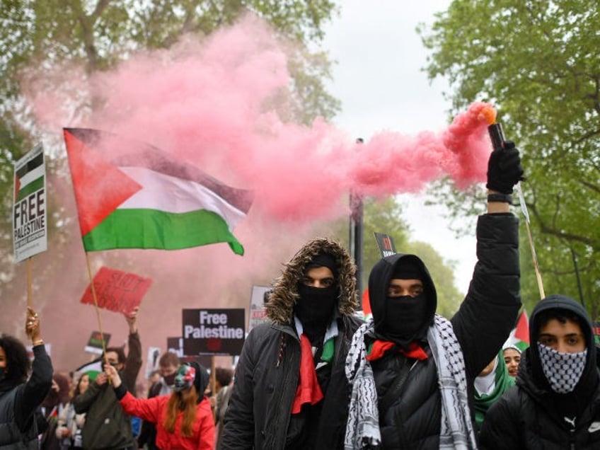 Pro-Palestine demonstrators hold placards as they gather to march in central London on May 22, 2021. (Photo by JUSTIN TALLIS / AFP) (Photo by JUSTIN TALLIS/AFP via Getty Images)