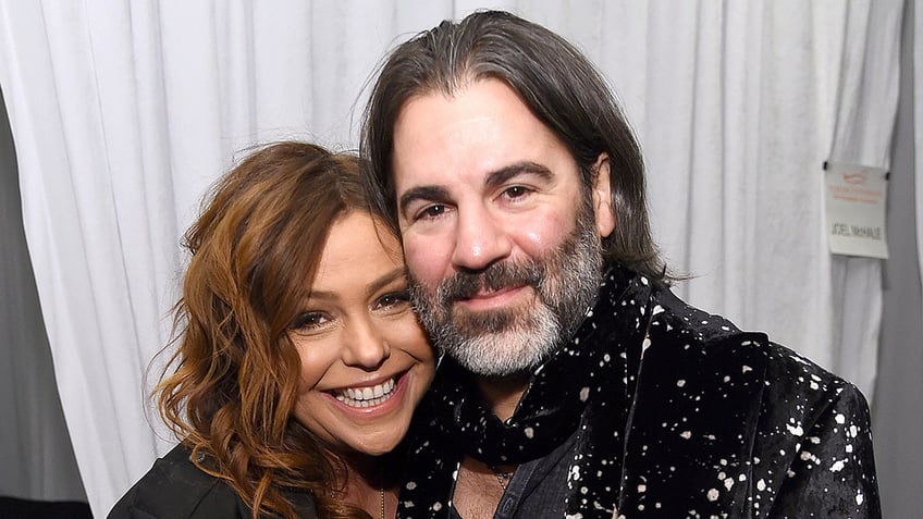 Celebrity chef Rachael Ray smiles next to husband John Cusimano.