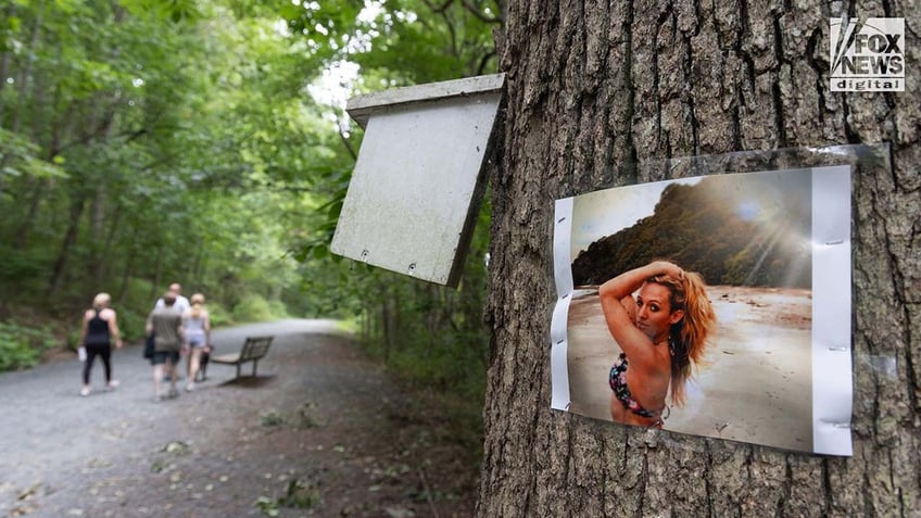 A photo of Rachel Morin is posted on a tree along a hiking route