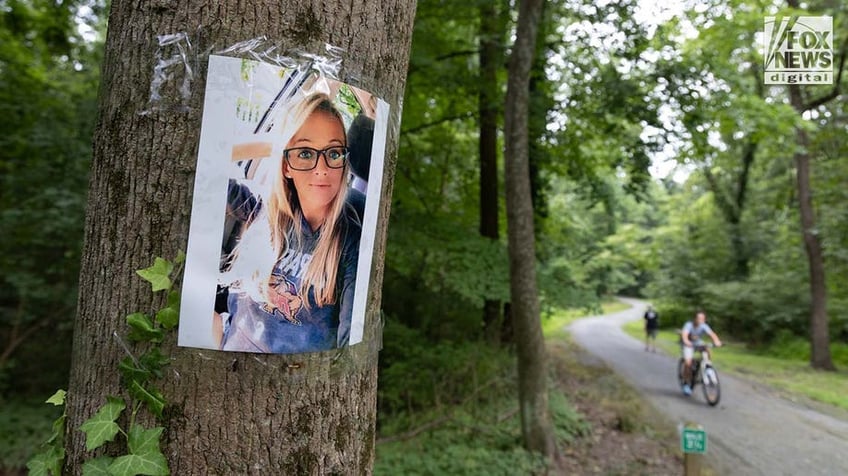 A photo of Rachel Morin is posted on a tree along a hiking route