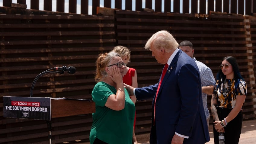 U.S. Republican Presidential Candidate and former President Donald Trump comforts Patty Morin