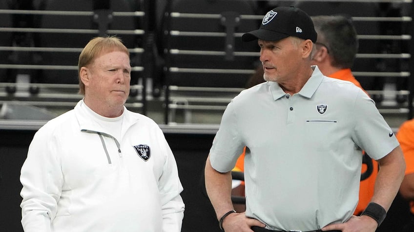 Mark Davis and Mike Mayock look on