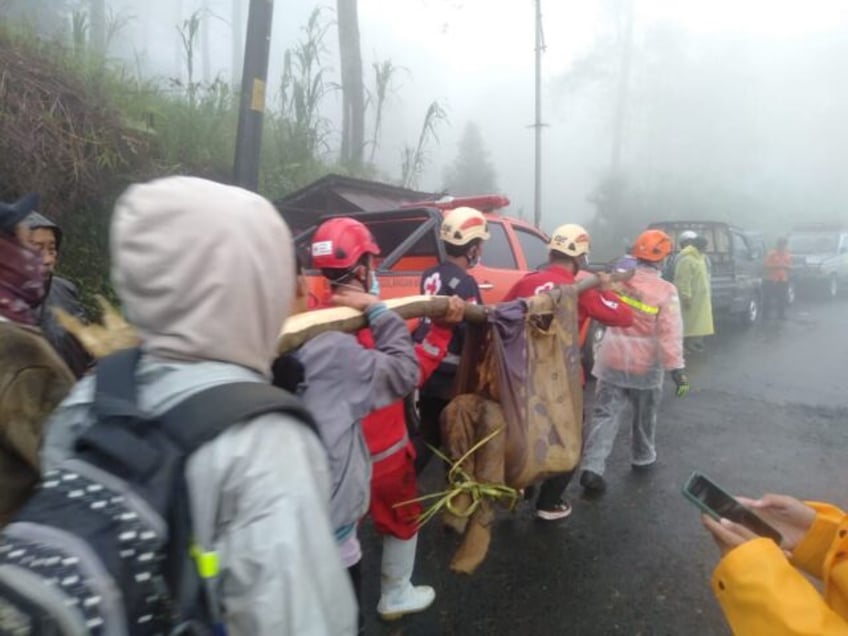 Rescuers and villagers evacuate victims of a landslide in Pekalongan, Central Java that ki