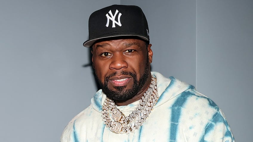Rapper 50 Cent wears tie-dyed sweatshirt and diamond necklaces with New York Yankees hat