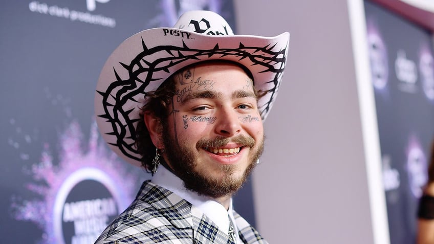 Rapper Post Malone wears pink cowboy hat and matching suit.