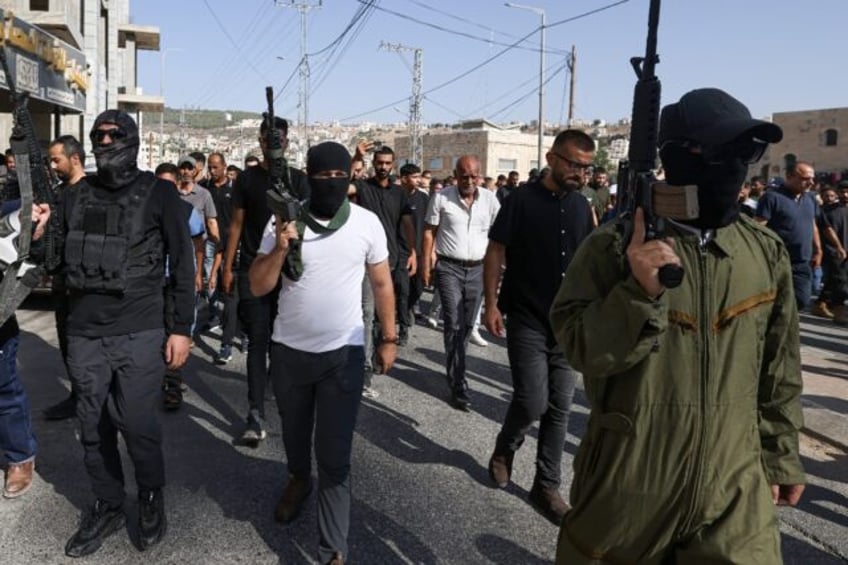 Palestinian militants in the funeral procession for men killed in an Israeli air strike in