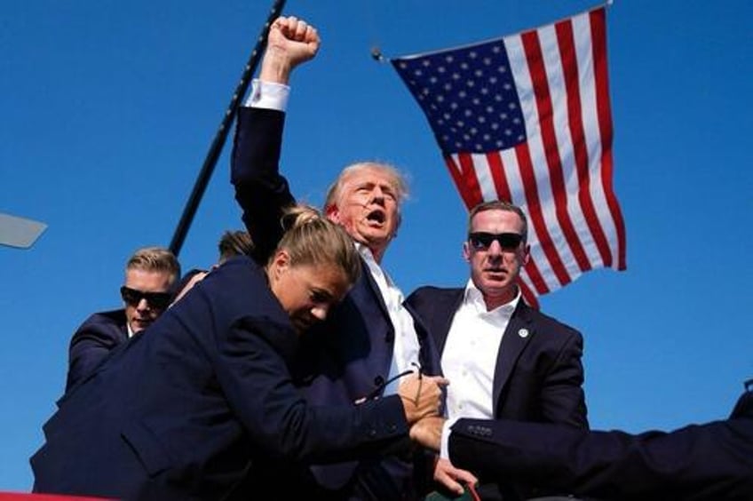 Trump standing with his fist raised after the attempt on his life. 