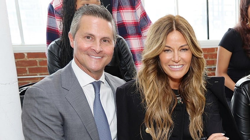 Reality star Kelly Bensimon wears black coat at fashion week with Scott Litner.