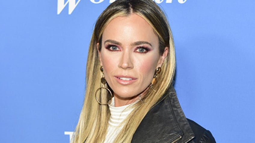 Teddi Mellencamp wears brown coat on the red carpet.