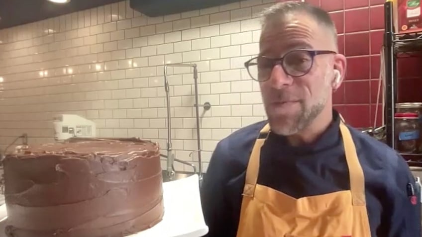 James Beard Award-nominated chef Gregory Leon stands next to a devil's food cake he made.