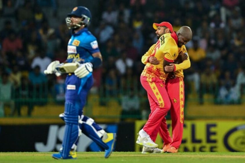 Zimbabwe's Luke Jongwe celebrates with Sikandar Raza (R) after taking the wicket of Sri Lanka's Kusal Mendis (L) during the second T20 between Sri Lanka and Zimbabwe