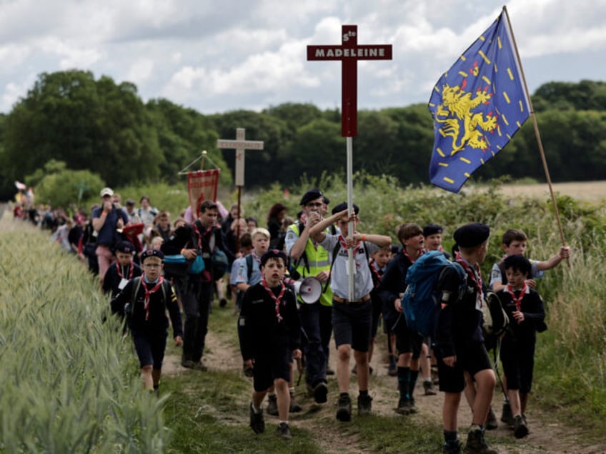 Pelgrins hold crosses, banners and flags as they arrive for the Mass, during the tradition