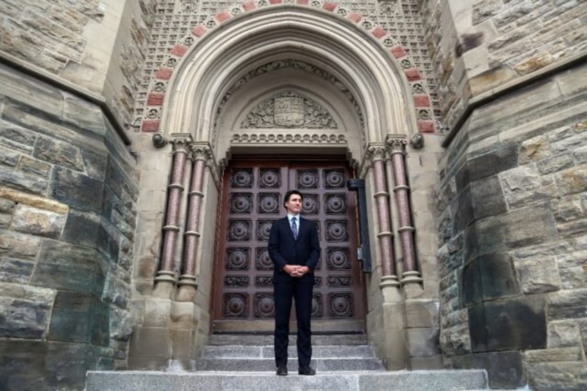 Canada's Prime Minister Justin Trudeau stands at the entrance of parliament, which until r