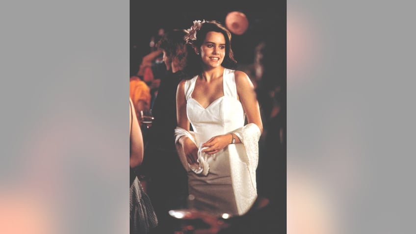 Ione Skye wearing a white dress in a scene from the movie Say Anything.