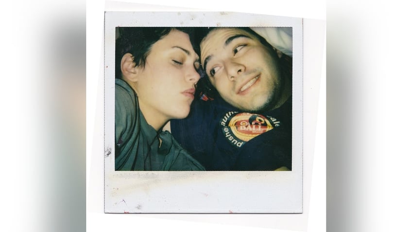 A polaroid of Ione Skye sleeping as Adam Horovitz looks at her.