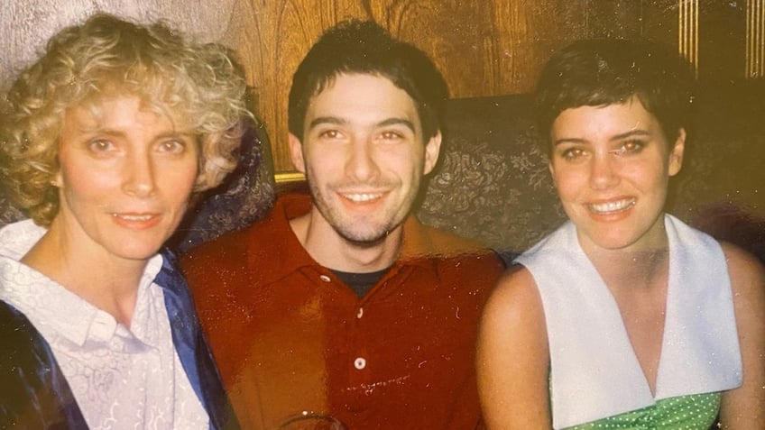 Ione Skye's mother, Adam Horovitz and Ione sitting together on a couch and smiling.