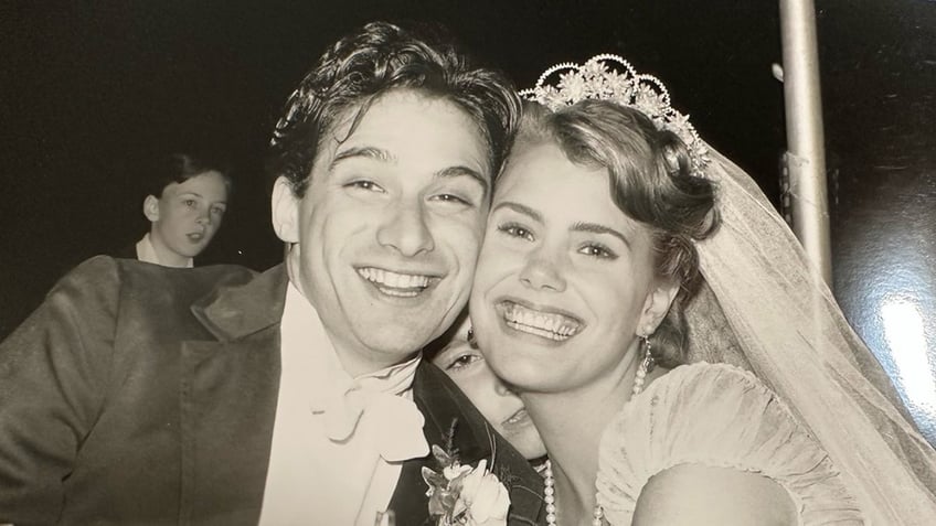 A close-up of Adam Horovitz and Ione Skye smiling on their wedding day.