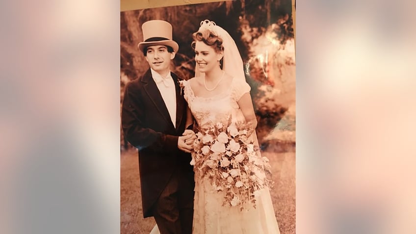 Adam Horovitz and Ione Skye dressed as bride and groom on their wedding day.