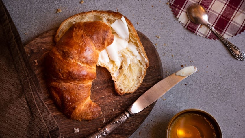 Fresh baked sweet croissants with honey for breakfast