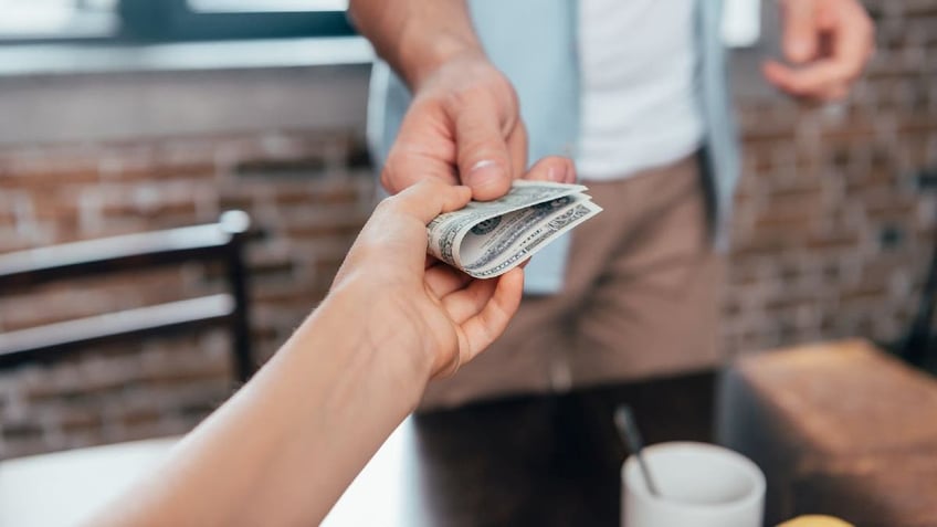 Father hands money to daughter