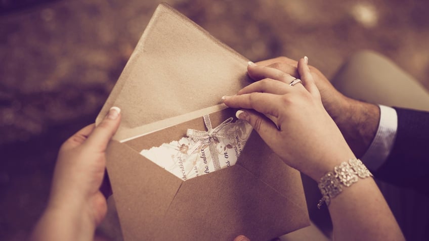 Guests open mailed invitation together