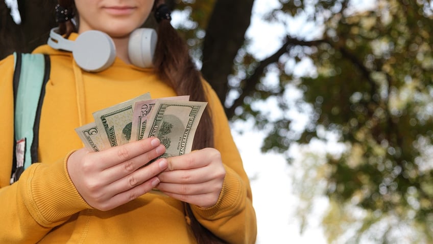 little girl holding money from parent