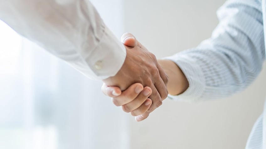 Man and woman shaking hands.