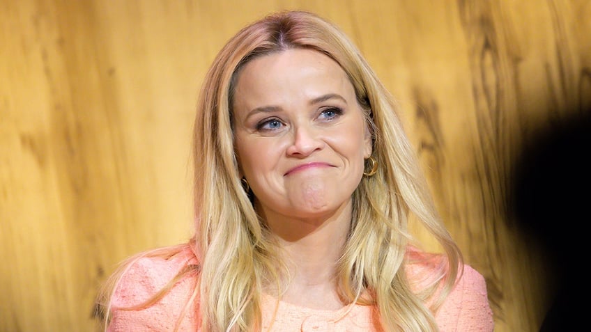 Reese Witherspoon wears orange dress at Los Angeles event.