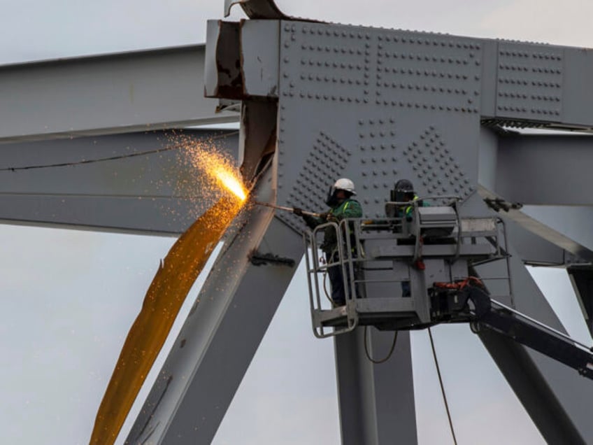 In this photo provided by the U.S. Coast Guard, demolition crews begin cutting the top por