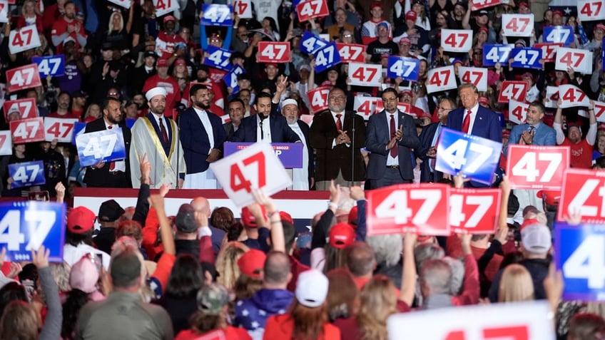 Republican presidential nominee former President Donald Trump stands alongside local Muslim leaders during a campaign rally at the Suburban Collection Showplace, Saturday, Oct. 26, 2024 in Novi, Mich. 