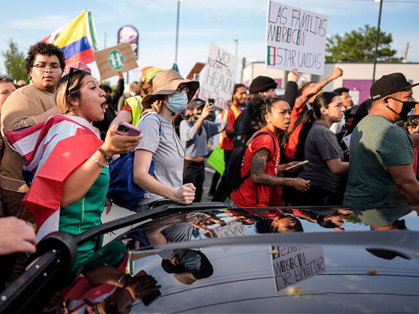 Protesters speak to authorities after the arrest of a man detained by police during an imm