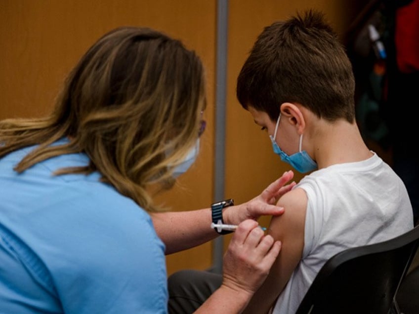 A child, 11, receives the Pfizer-BioNTech Covid-19 vaccine for children in Montreal, Quebec on November 24, 2021. - Today is the first day that children are allowed to receive the version of the vaccine designed for children aged 5 to 11 years old in Canada. (Photo by Andrej Ivanov / AFP) (Photo by ANDREJ IVANOV/AFP via Getty Images)